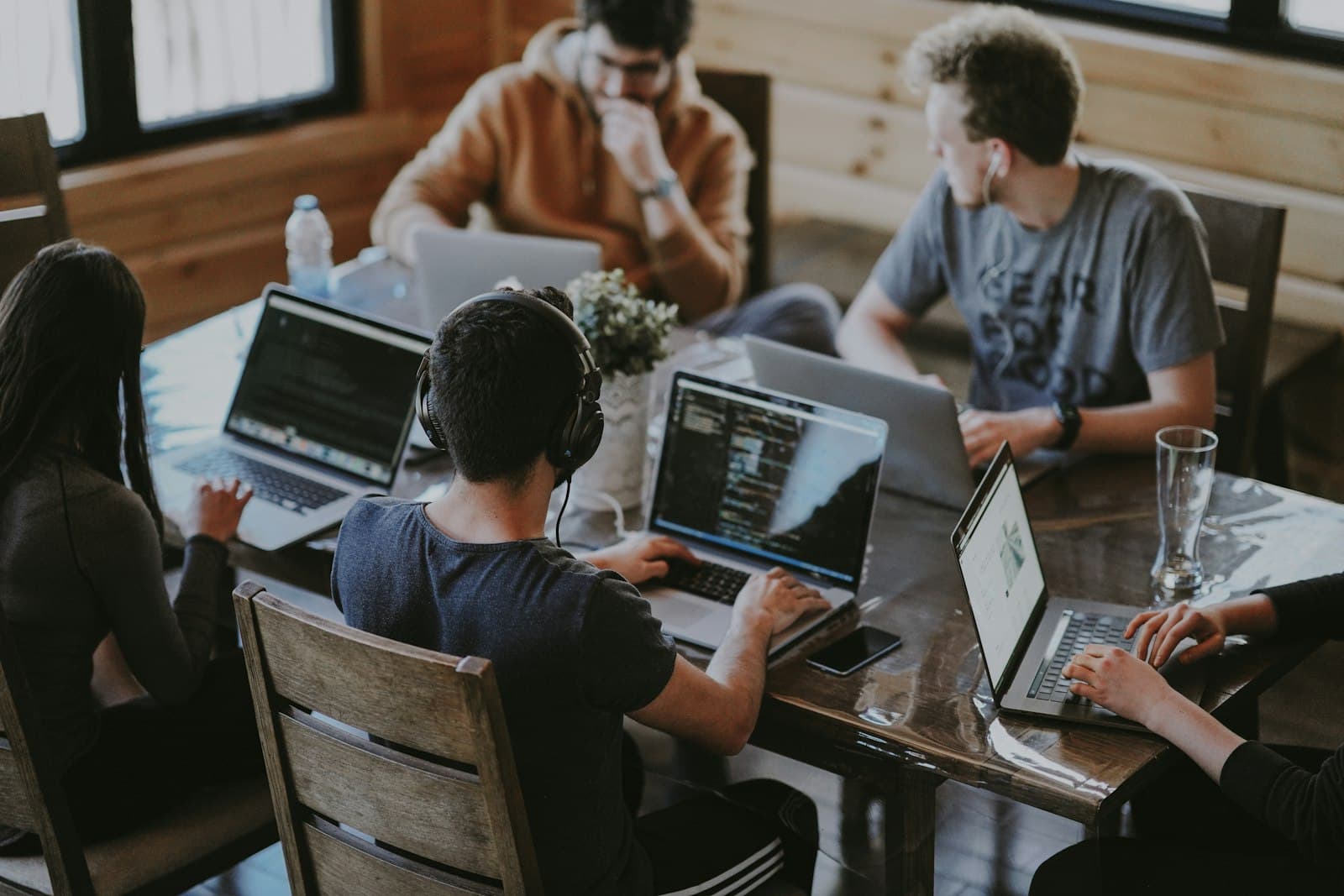 Small team collaborating around laptops at a shared workspace