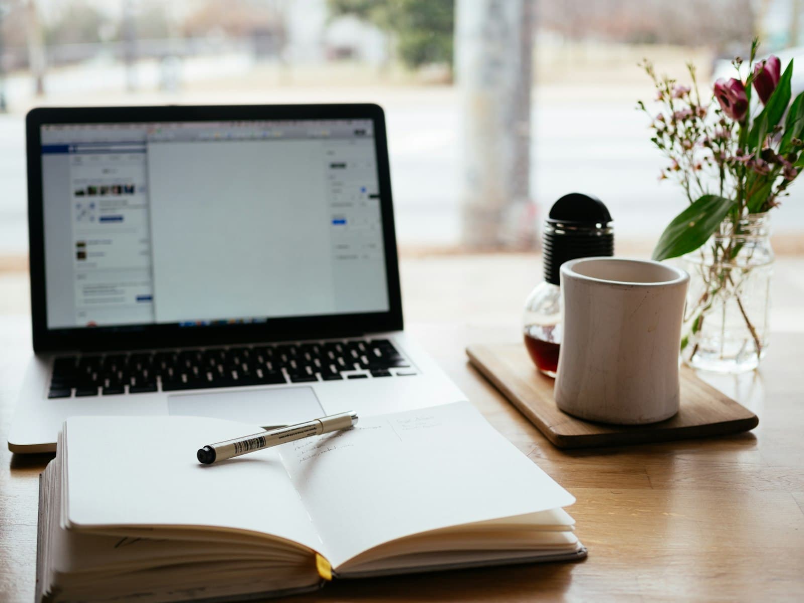 Laptop and notebook on desk for writing workflow automation insights and guides